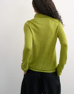 Model wearing Knitted wool blend double layer sheer turtleneck top in green