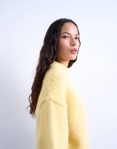 Model wearing Knitted wool blend fluffy exposed seam easy jumper in butter yellow