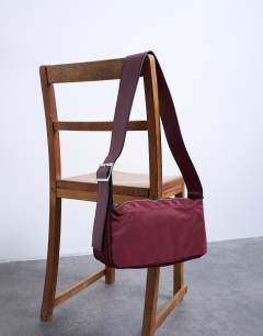 Model wearing Kyliemedium nylon cross body with contrast strap in burgundy
