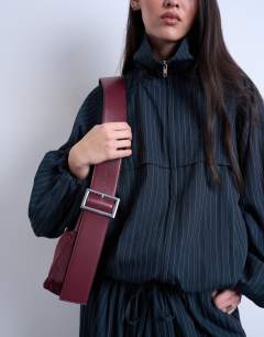 Model wearing Kyliemedium nylon cross body with contrast strap in burgundy