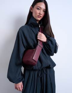 Model wearing Kyliemedium nylon cross body with contrast strap in burgundy