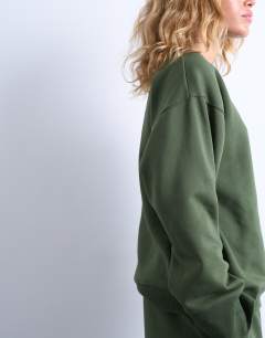 Model wearing La paloma embroidered sweatshirt co-ord in green