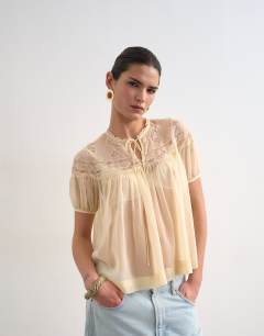 Model wearing Lace detail short sleeve top with tie in ivory