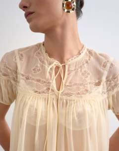 Model wearing Lace detail short sleeve top with tie in ivory