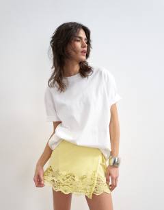 Model wearing Lace hem wrap mini skirt in buttermilk