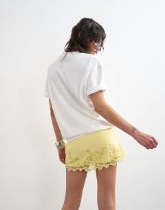 Model wearing Lace hem wrap mini skirt in buttermilk