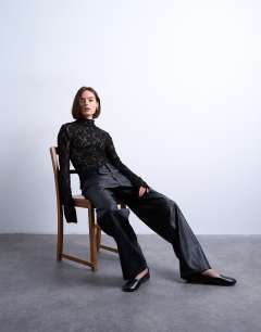 Model wearing Lace high neck long sleeve asymmetric hem top in black
