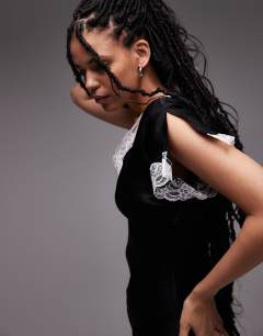 Model wearing Lace insert mini dress with asymmetric sleeve in white and black