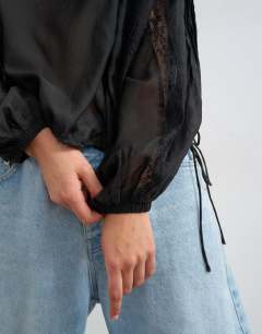 Model wearing Lace trim ruched side blouse in black