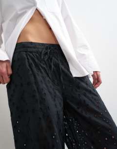 Model wearing Large broderie cut out tie waist trouser in black