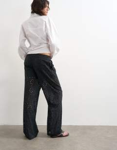 Model wearing Large broderie cut out tie waist trouser in black