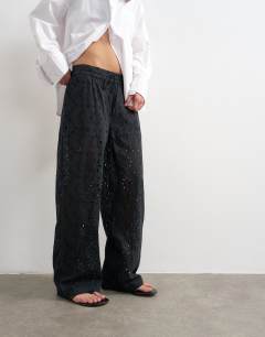 Model wearing Large broderie cut out tie waist trouser in black