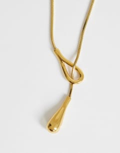 Model wearing Leah lariat necklace with bead in stainless gold