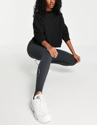 Topshop - Legging met bandjes onder de voet en grafische print op  broekspijp in zwart met wassing | ASOS