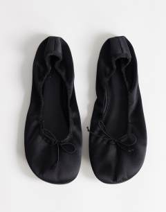 Model wearing Lila round toe ballet flat in black satin