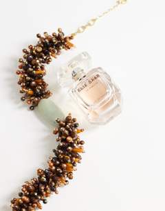 Model wearing Lillian statement semi precious beaded necklace in brown and sage