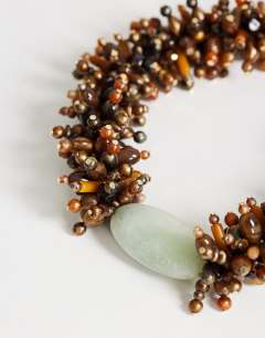 Model wearing Lillian statement semi precious beaded necklace in brown and sage