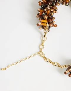 Model wearing Lillian statement semi precious beaded necklace in brown and sage