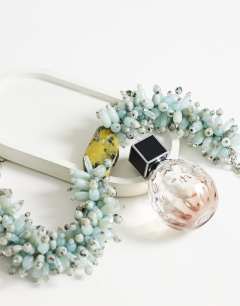 Model wearing Lillian statement semi precious beaded necklace in silver and blue