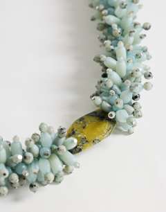 Model wearing Lillian statement semi precious beaded necklace in silver and blue