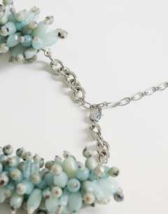 Model wearing Lillian statement semi precious beaded necklace in silver and blue