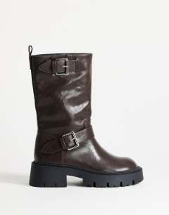Model wearing Lincon chunky mid calf boot with buckles in choc
