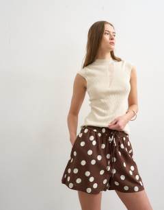 Model wearing Linen A line polka dot short in brown