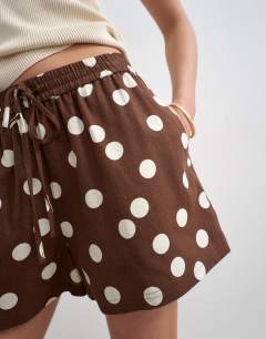 Model wearing Linen A line polka dot short in brown