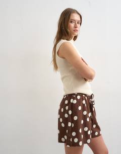 Model wearing Linen A line polka dot short in brown
