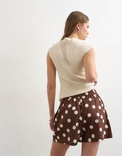 Model wearing Linen A line polka dot short in brown