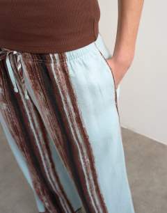 Model wearing Linen blue painted stripe straight leg trouser with deep cuff in blue