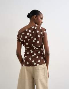 Model wearing Linen cinched waist asymmetric twist shoulder top in chocolate spot