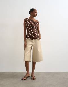 Model wearing Linen cinched waist asymmetric twist shoulder top in chocolate spot