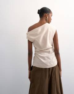 Model wearing Linen cinched waist asymmetric twist shoulder top in natural