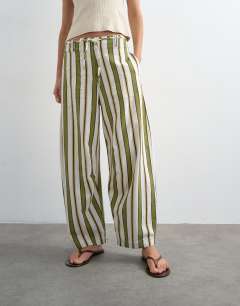 Model wearing Linen green stripe clean tie waist barrel trouser in green