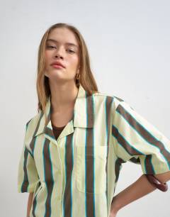 Model wearing Linen resort shirt in lime and chocolate stripe