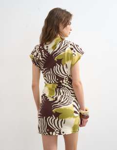 Model wearing Linen rich drape asymmetric mini dress in khaki and brown abstract animal print