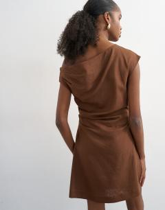 Model wearing Linen rich fallen shoulder mini dress with tucked waist in chocolate