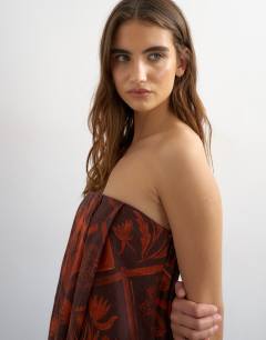 Model wearing Linen rich full trapeze bandeau mini dress in rust boutique scarf print