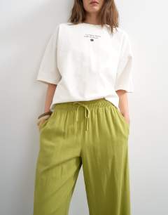 Model wearing Linen straight leg trouser with deep cuff in mid green