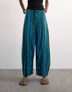 Model wearing Linen stripe clean tie waist barrel trouser in blue