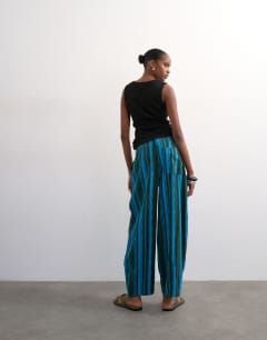Model wearing Linen stripe clean tie waist barrel trouser in blue