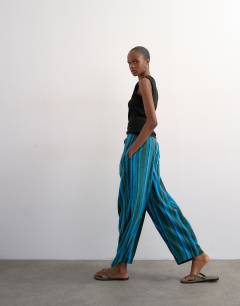 Model wearing Linen stripe clean tie waist barrel trouser in blue