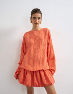 Model wearing Long sleeve blouson mini dress in bright coral