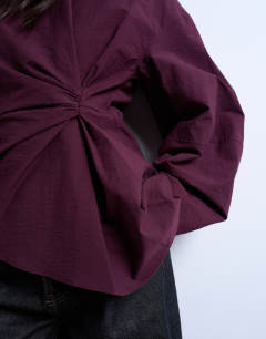 Model wearing Long sleeve pleat front top in burgundy
