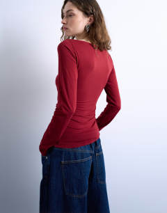 Model wearing Long sleeve ruched slash neck top in dark red