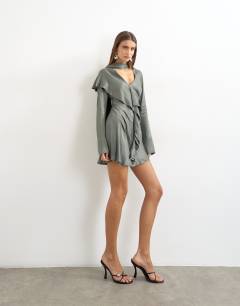 Model wearing Long sleeve ruffle mini dress with scarf wrap detail in petrol blue