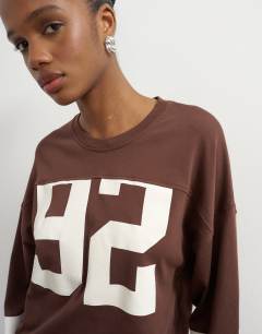Model wearing Long sleeve skater '92' graphic t-shirt in chocolate