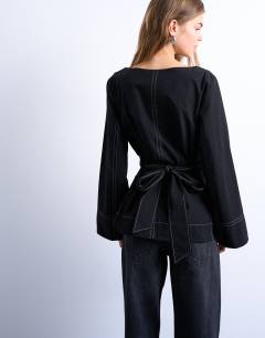 Model wearing Long sleeve tie waist top in black with contrast stitch