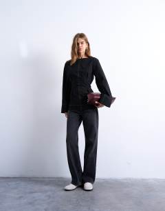 Model wearing Long sleeve tie waist top in black with contrast stitch